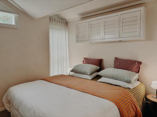 a bedroom with a bed with two pillows on it at Slow Haus Tanunda in Tanunda