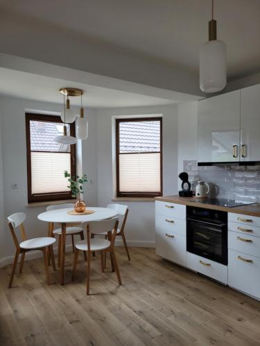 a kitchen with a table and chairs in a kitchen at Start na Szlak - dom Rytro in Rytro