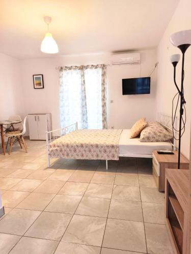 a bedroom with a bed and a tv on the wall at Studio Stela 3 in Povljana