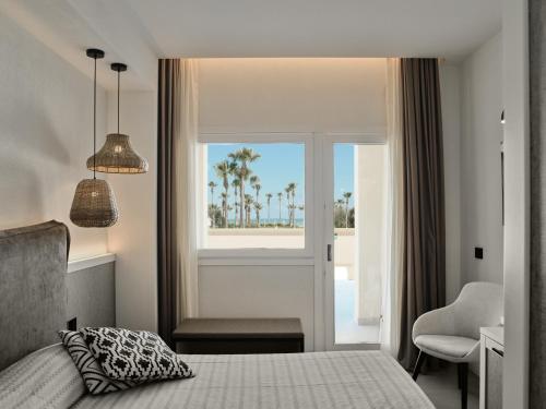 a bedroom with a bed and a view of the ocean at Mangia's Himera Resort in Campofelice di Roccella