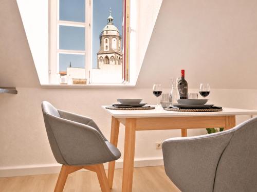 a table with two chairs and a table with wine glasses at Fynbos Studio DG in der Altstadt, Frauenkirchenblick, Parkplatz in Meißen