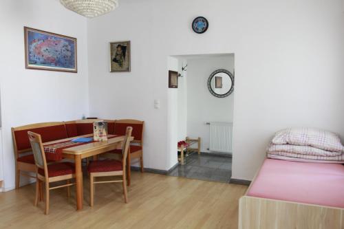 a room with a table and a bed and a table and chairs at Stay-In Vienna 23 in Vienna