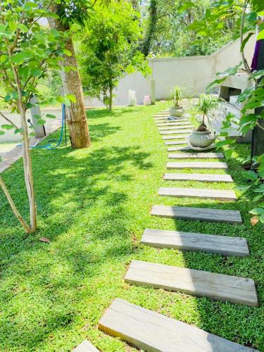 a garden with stepping stones on the grass at Monara Blue Beach in Dickwella