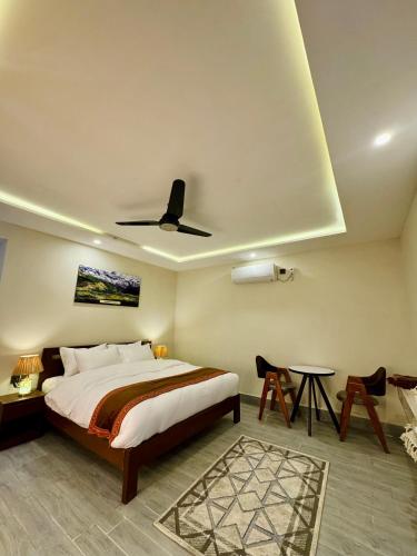 a bedroom with a bed and a ceiling fan at Meechung Resort in Skardu
