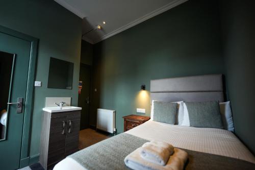 a bedroom with a bed with two towels on it at The Whisky Vaults in Oban