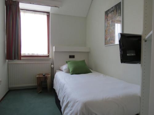 a small room with a bed and a television at Hotel Schilberg in Slenaken