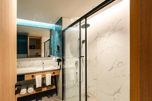 a bathroom with a shower and a sink at Orchid Parc Bengaluru - Manyata Business Park in Bangalore