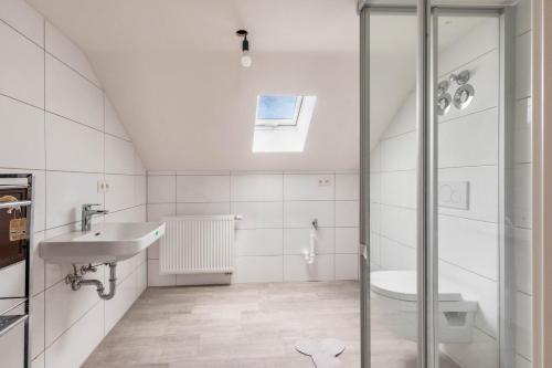 a white bathroom with a sink and a shower at Loft in Augsburg