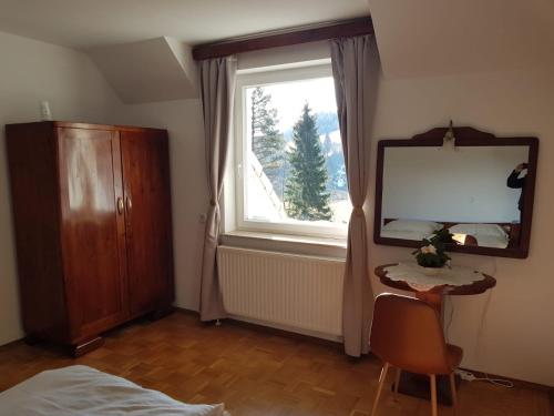 a bedroom with a mirror and a dresser and a window at Oaza Narave Apartment, Peaceful Retreat near Bled & Vintgar in Spodnje Gorje
