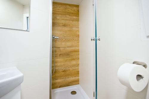 a bathroom with a toilet and a glass shower door at MOLO RESORT KEMPING in Osiek