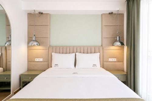 a bedroom with a large white bed with two pillows at Palheiro 81 in Costa Nova