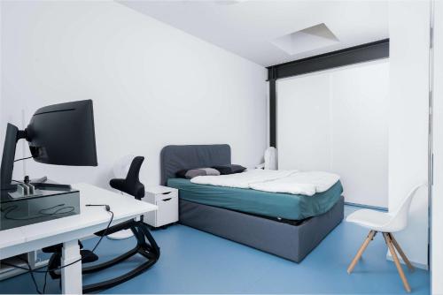 a bedroom with a bed and a desk with a computer at Modern Zurich Apt with Balcony View & Workspace in Zurich