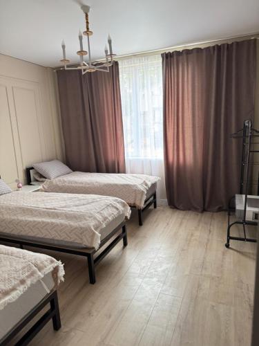 a room with three beds and a window at The Bay Apartments in Cholpon-Ata
