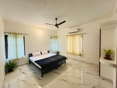 a bedroom with a bed and a ceiling fan at Zenways in Varkala