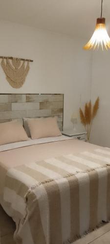 a bedroom with a large bed with a blanket on it at Hospedaje El Ciruelo in Alta Gracia