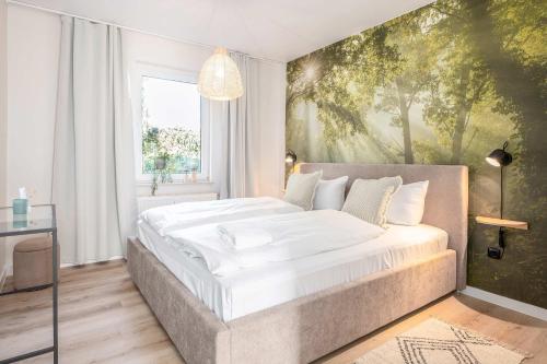 a bedroom with a large bed with a painting on the wall at Green Village Igelnest in Benz