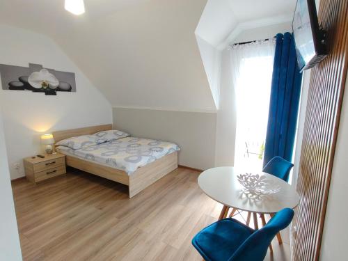 a small bedroom with a bed and a table at Noclegi Pod Lasem in Polańczyk