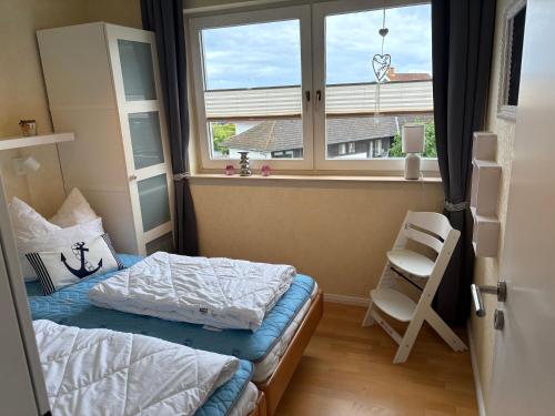 a small bedroom with a bed and a window at Ostseeliebe in Grömitz