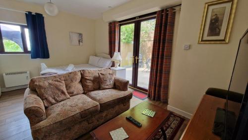 a living room with a couch and a table at The Nook - Farm Park Stay with Hot Tub & Dome in Swansea