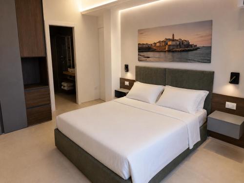 a bedroom with a white bed and a painting on the wall at B&B LE MAGNOLIE in Termoli