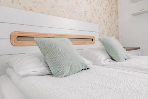two beds with white sheets and blue pillows at Apartament de închiriat in Borsec