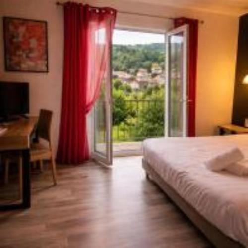 a bedroom with a bed and a desk and a window at Hôtel de Charme By Arts & Millésimes in Essoyes