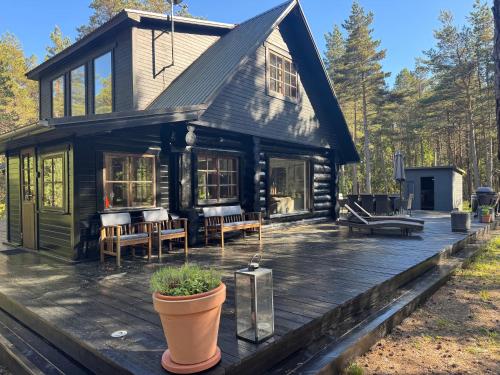 a log cabin with a porch and a deck at Wild Beach Spa in Kihelkonna