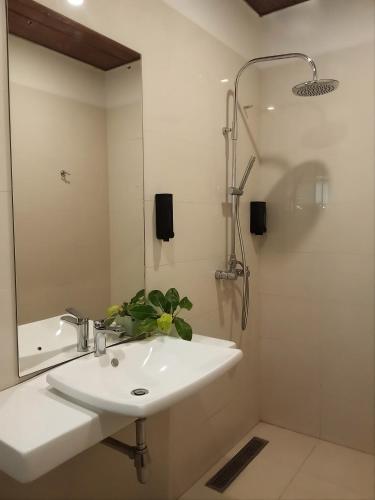 a white bathroom with a sink and a shower at Pekoe Bungalow Bambarakanda Waterfall and Pekoe Trail Retreat in Welegama