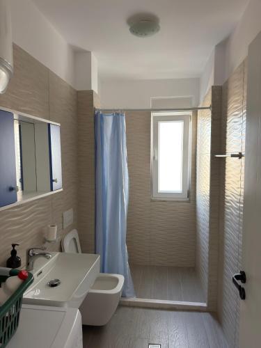 a bathroom with a sink and a toilet and a shower at Shengjin Paradise Apartment in Shëngjin