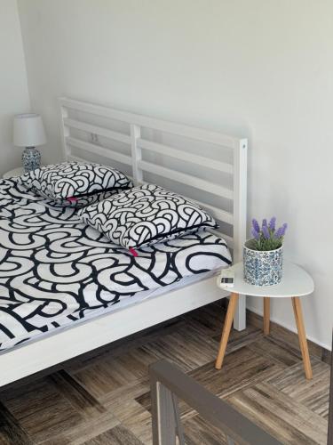 a white bed with black and white pillows and a table at Hedona227 in Perlez