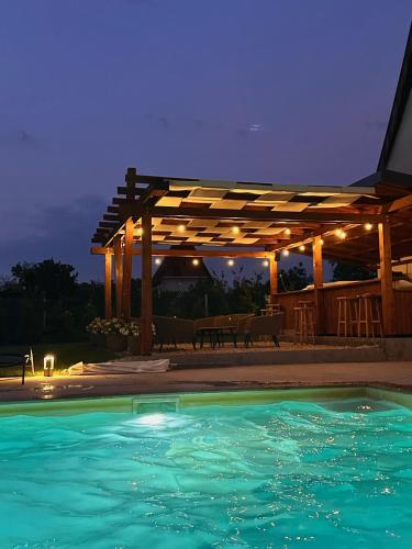 a swimming pool in front of a pergola at night at Hedona227 in Perlez