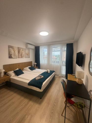 a large bedroom with two beds and a table at Апартаменти Лилия 2 in Primorsko