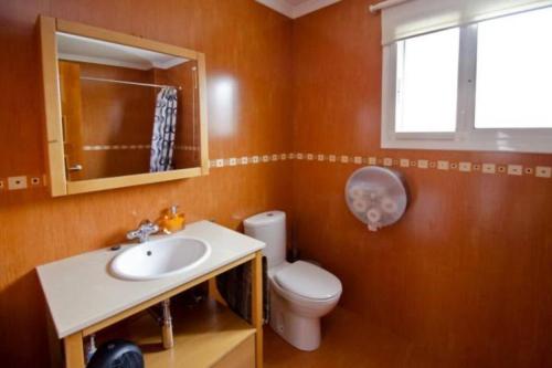 a bathroom with a toilet and a sink and a window at Villa Castelló Salou (cerca Port Aventura) in Salou