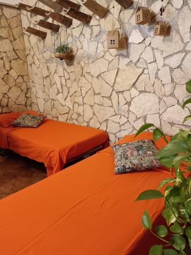 two beds in a room with a stone wall at Il Posto delle Rose 2 in San Polo dei Cavalieri