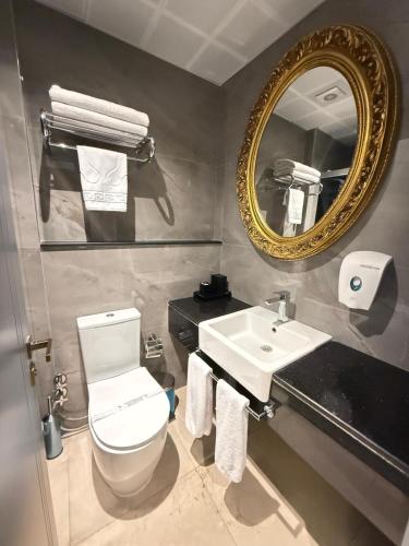 a bathroom with a toilet and a sink and a mirror at Residence Hotel By Ketenci in İzmir