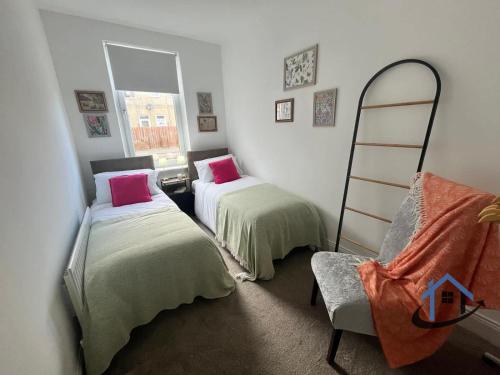 a room with two beds and a ladder and a chair at 28 Victoria Terrace, Bedlington, ground floor in Bedlington