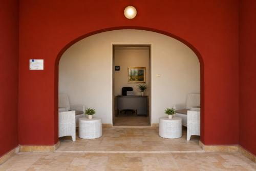 an archway leading into an office with white chairs and a desk at Agriturismo Caranna in Torre Lapillo