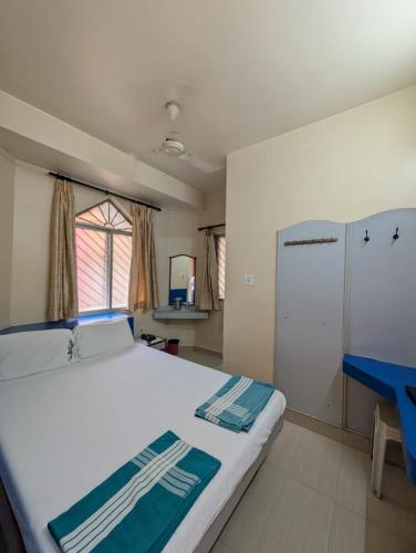 a bedroom with a large bed and a blue table at Vinayaka Lodge in Bangalore