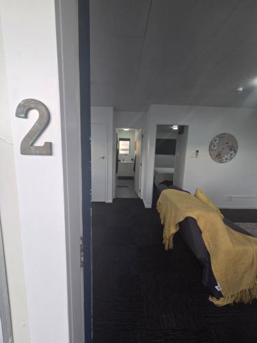 a room with two beds and a number on the wall at Te Whare Whitiora in Hamilton