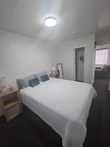a bedroom with a large white bed in a room at Te Whare Whitiora in Hamilton