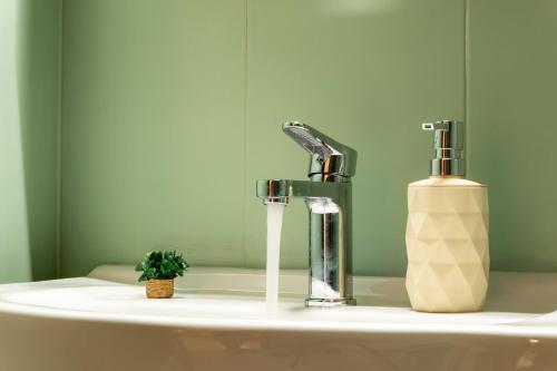 a bathroom sink with a faucet and a bottle of soap at Nesto Living in Chóra