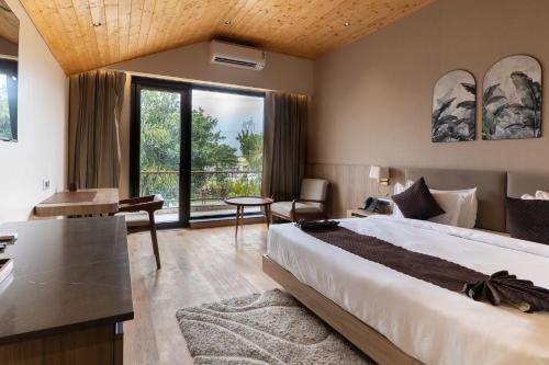 a bedroom with a bed and a desk and a window at Justa Natures Nest Resort in Bullāwāla