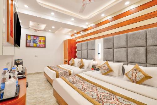 a hotel room with two beds and a table at Hotel Vedas Heritage - Karol Bagh - Newly Renovated in New Delhi