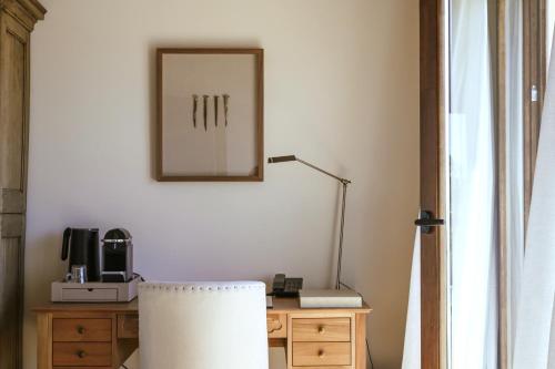 a desk with a lamp and a mirror on a wall at Palacio de Paradinas in Santa María la Real de Nieva