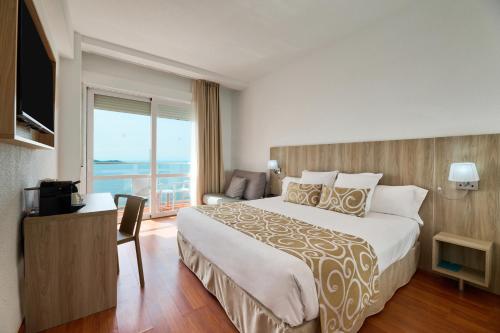 a hotel room with a large bed and a balcony at AluaSun Doblemar in La Manga del Mar Menor