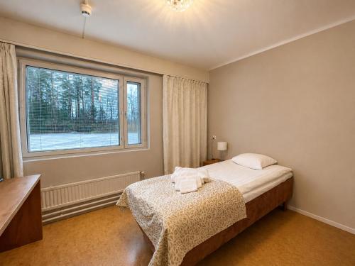 a bedroom with a bed and a window at Backbyn Kartano in Espoo