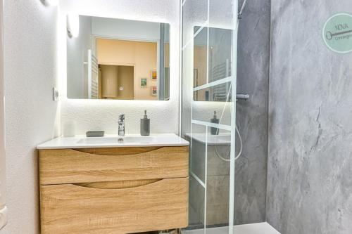 a bathroom with a sink and a mirror at Le Belvédère des Dunes in Saint-Gilles-Croix-de-Vie