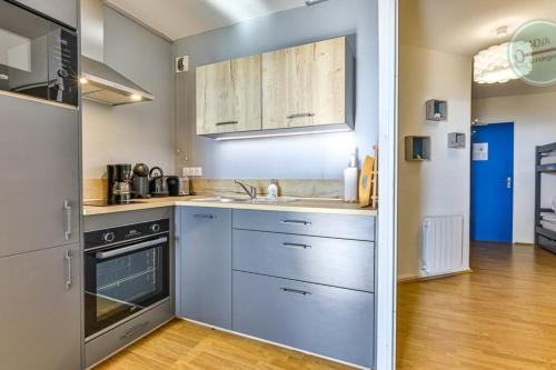 a kitchen with a sink and a stove at Le Belvédère des Dunes in Saint-Gilles-Croix-de-Vie