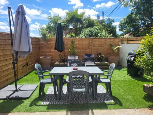 a patio with a table and chairs and an umbrella at Studio Cosy in Saint-Lon-les-Mines