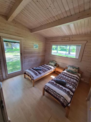 a room with two beds in a log cabin at Giruliu kopa in Melnragė